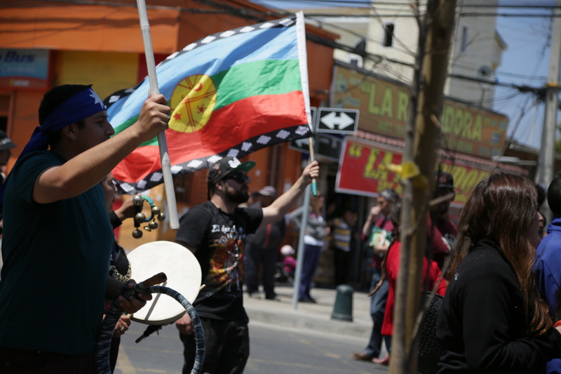 Asistentes en marcha Cartagena, bandera e instrumentos mapuche
